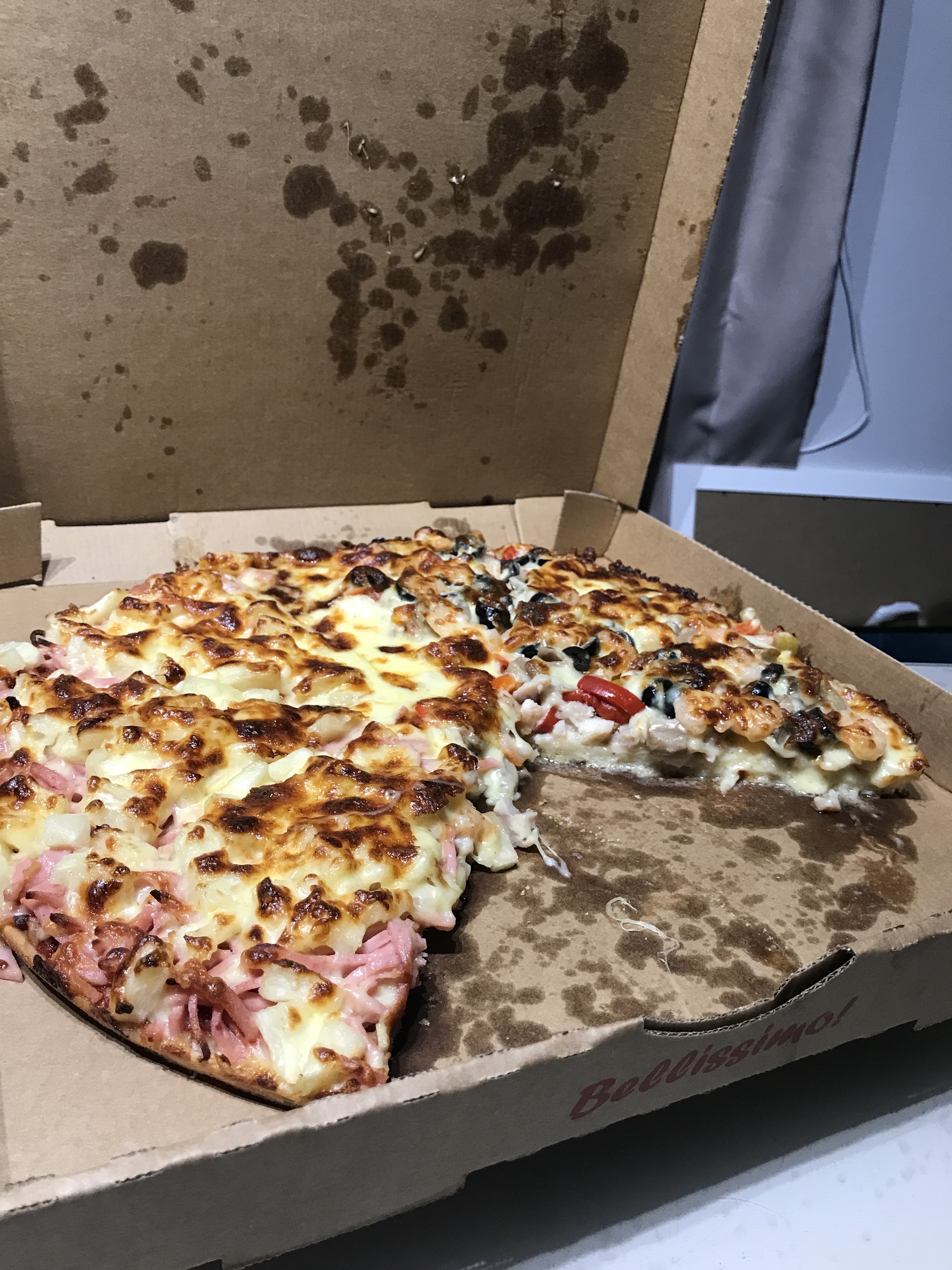A half and half pizza in the box from Crustys