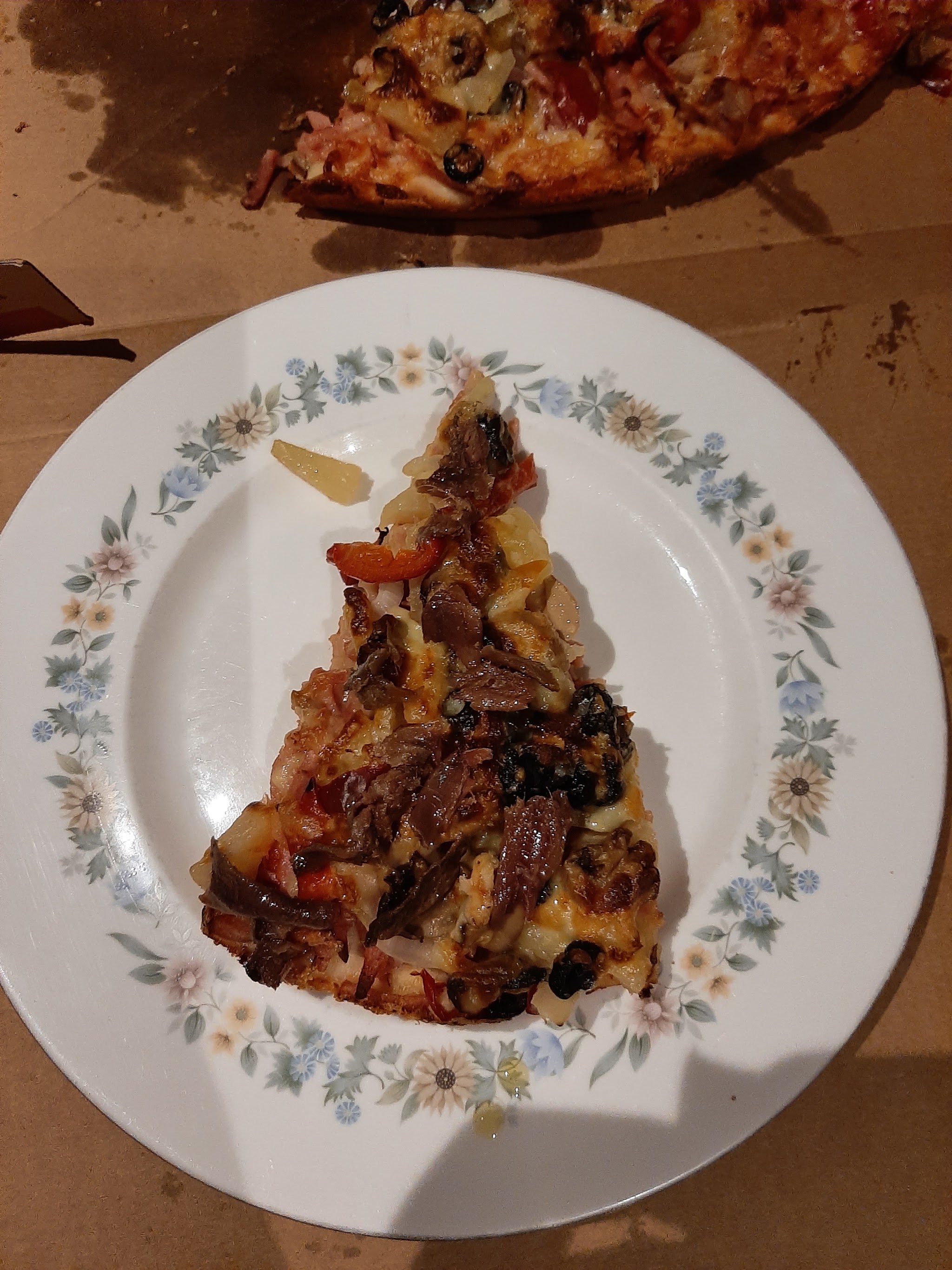 A loaded slice of Crustys pizza on a plate